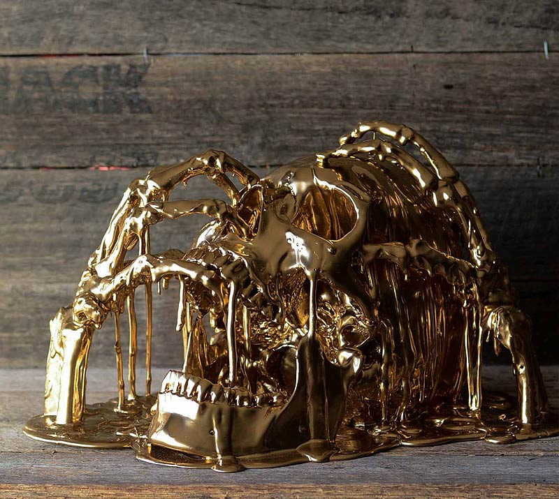 gold melting skull with hands